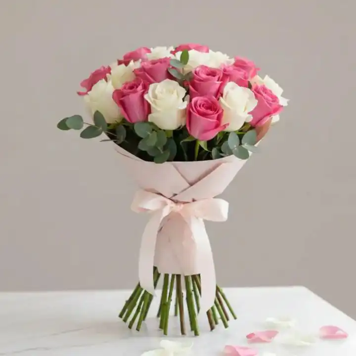 Pink & White Rose Bouquet 1 A hand-tied pink roses flower bouquet mixed with white blooms and lush green foliage against a soft background.