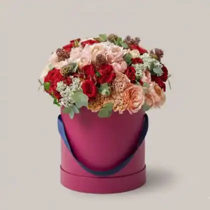 A luxurious Red Rose hatbox featuring vibrant crimson blooms tightly arranged in a sophisticated circular container.
