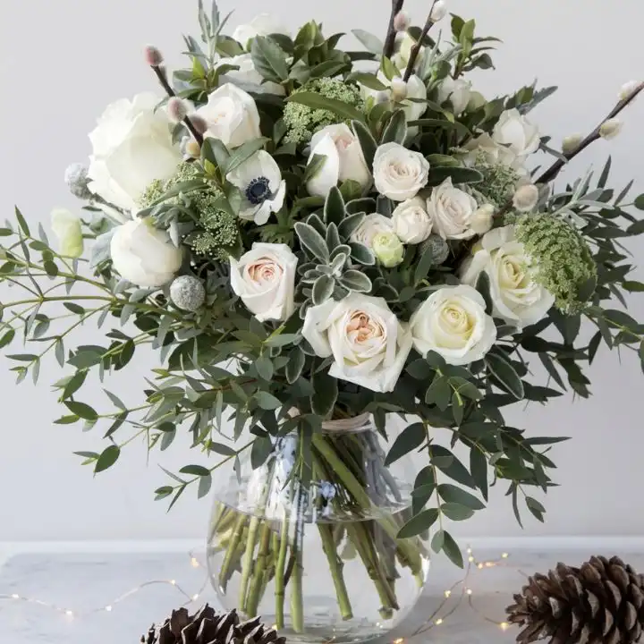 Hand-tied white rose and peony bouquet accented with delicate eucalyptus leaves and white ribbon.