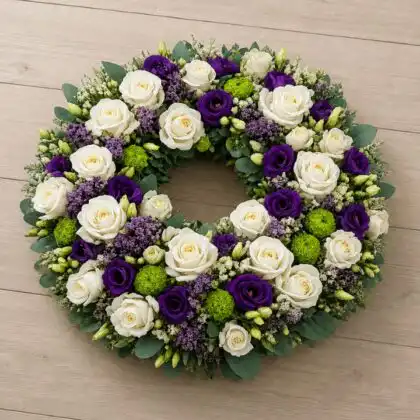 White rose and purple lisianthus funeral wreath with green chrysanthemum